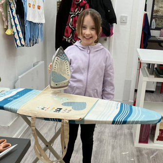 A child ironing her textiles project she has made at Explore, Make, Create.