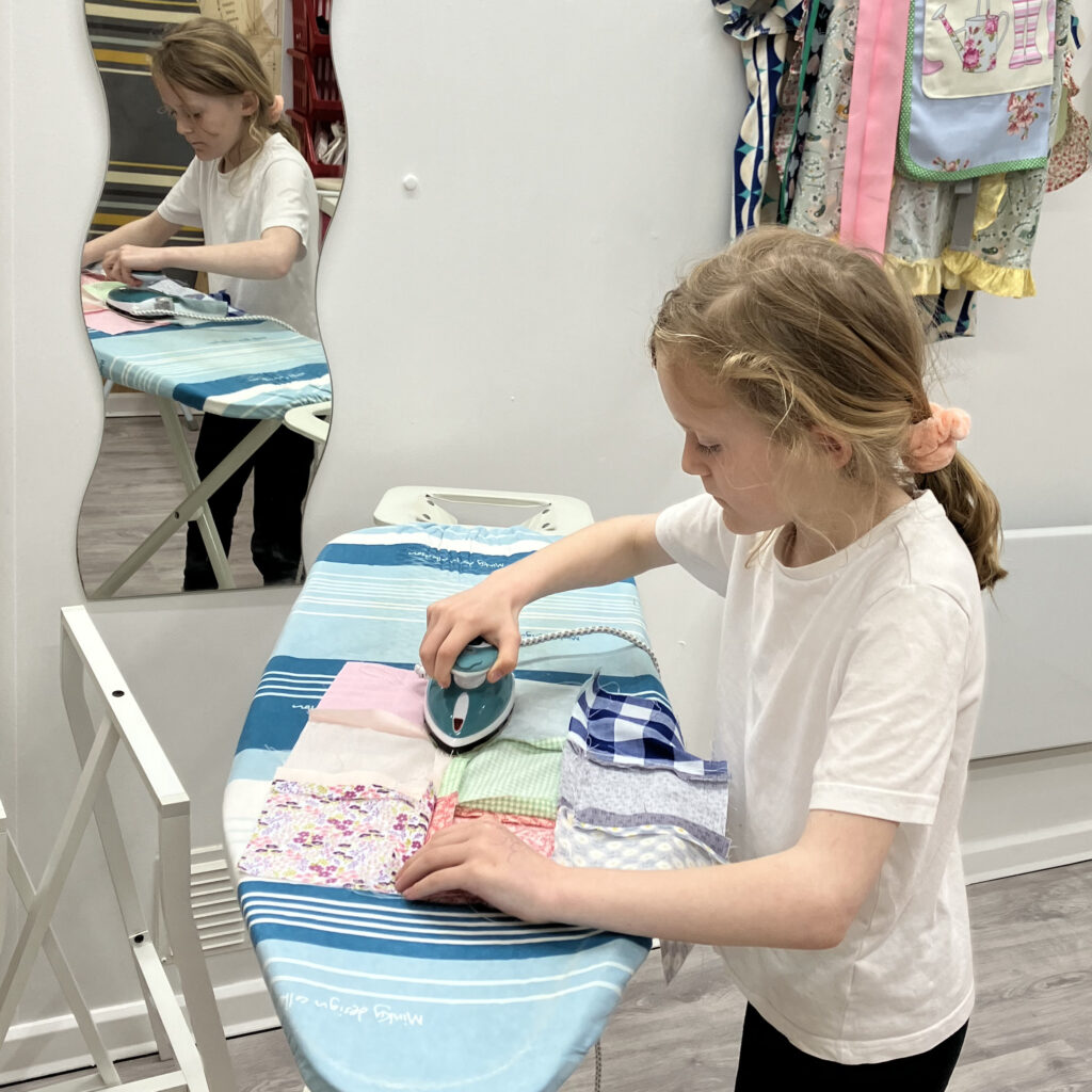 A young child finishing her textiles project