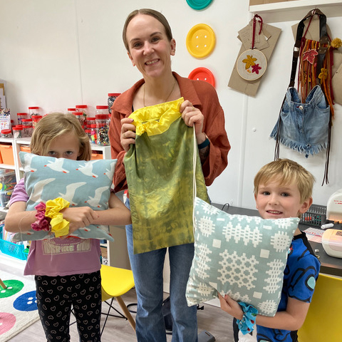 A family showing what they have made at a parent and child activity workshop
