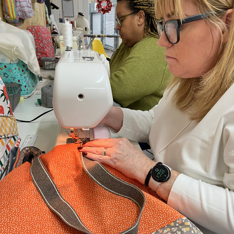 An adult at a sewing workshop in Manchester