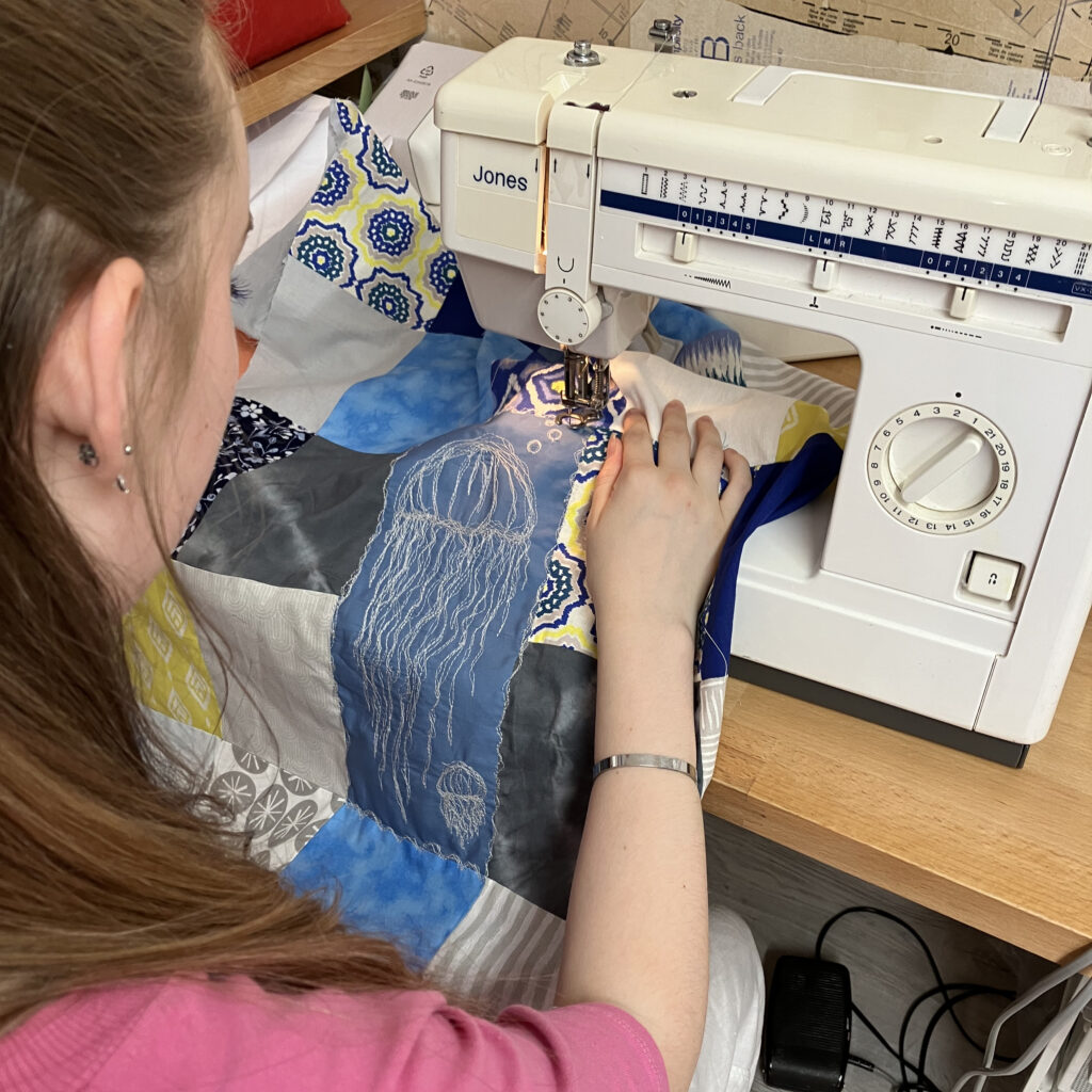 A teen embroidering art at GCSE textiles tuition class